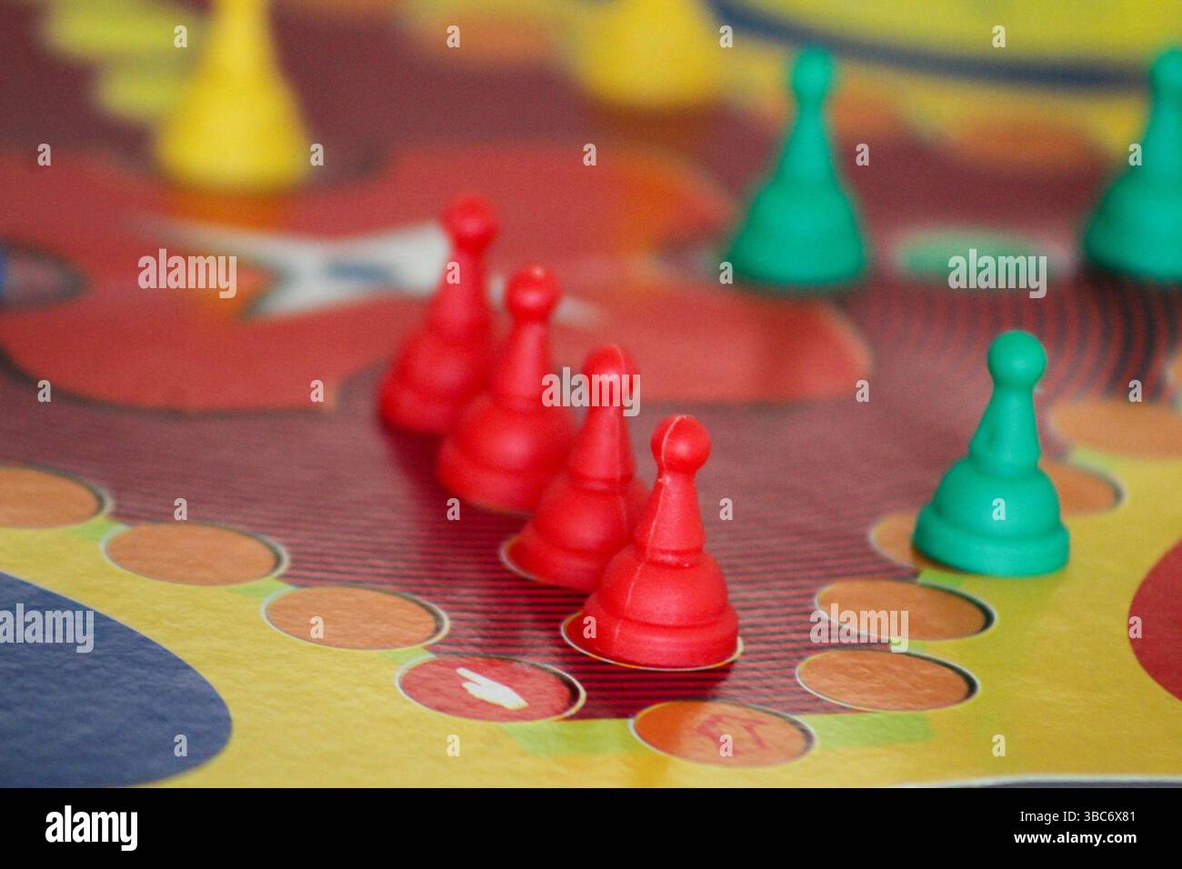 Primo piano di pedine rosse nell'area vincente di un gioco da tavolo Ludo. Classica configurazione di gioco da tavolo per tutta la famiglia con colori vivaci. Foto Stock