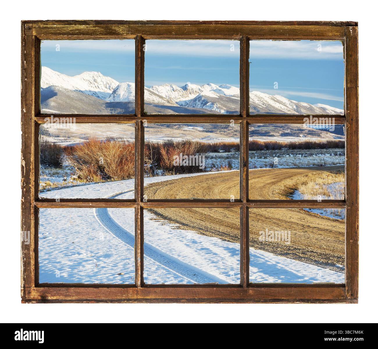 Concetto di viaggio - una vista di strada ventosa e montagne innevate attraverso vintage, grunge, finestra con vetri sporchi - Medicine Bow Mountains, Colorado Foto Stock