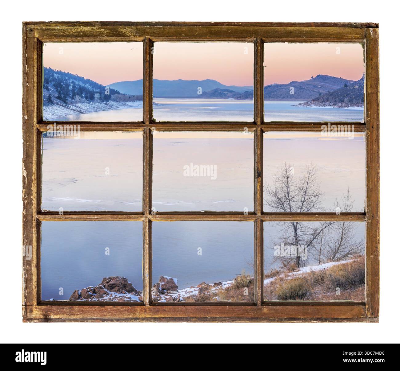 Crepuscolo sul lago di montagna in inverno, come si vede attraverso vintage, grunge, finestra a fascia con vetro sporco Foto Stock