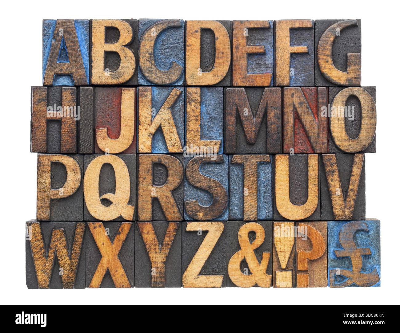 Alfabeto inglese con simboli di punteggiatura in blocchi di legno di stampa vintage macchiati da inchiostro blu, rosso e nero, isolati su bianco Foto Stock