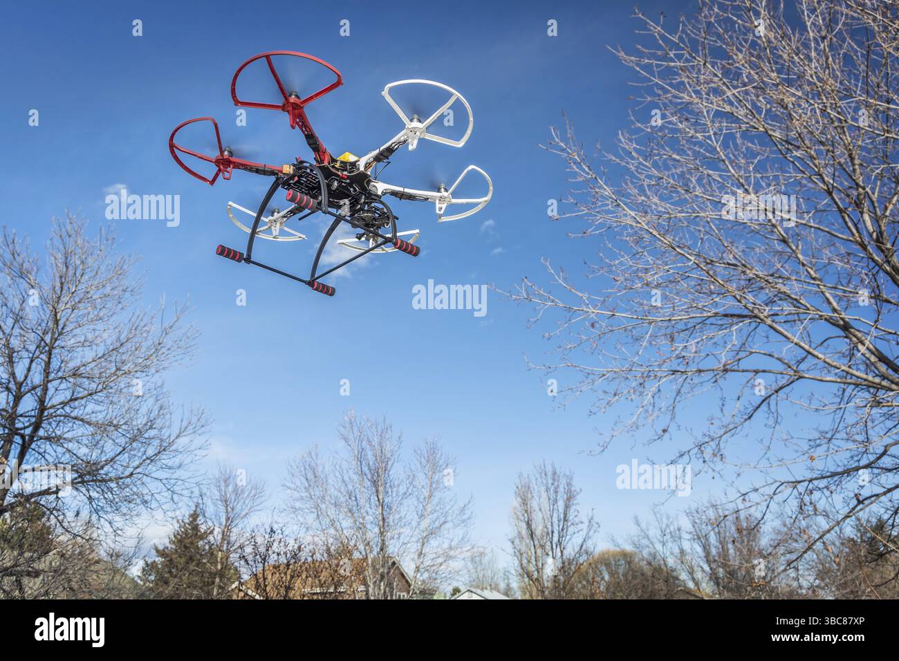 FORT COLLINS, CO, USA, 20 dicembre 2014: DJI F550 Flame Wheel hexacopter drone, assemblato da un kit, volando in un cortile tra alberi, Nord America Foto Stock