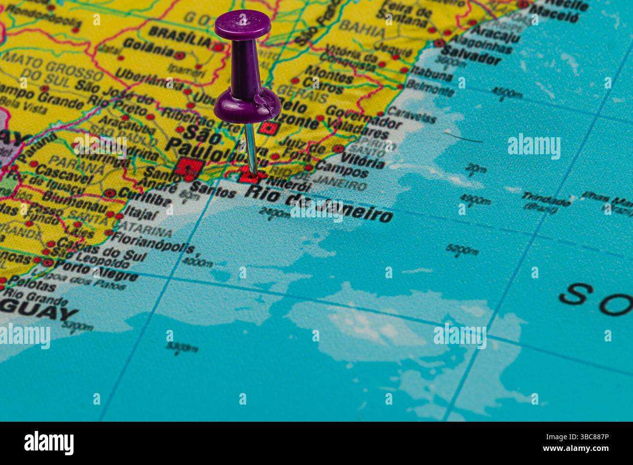 Una vista ravvicinata di una mappa che evidenzia la costa del Brasile. Una spilla viola è collocata a Rio de Janeiro e San Paolo, che mette in mostra questa vivace area urbana Foto Stock