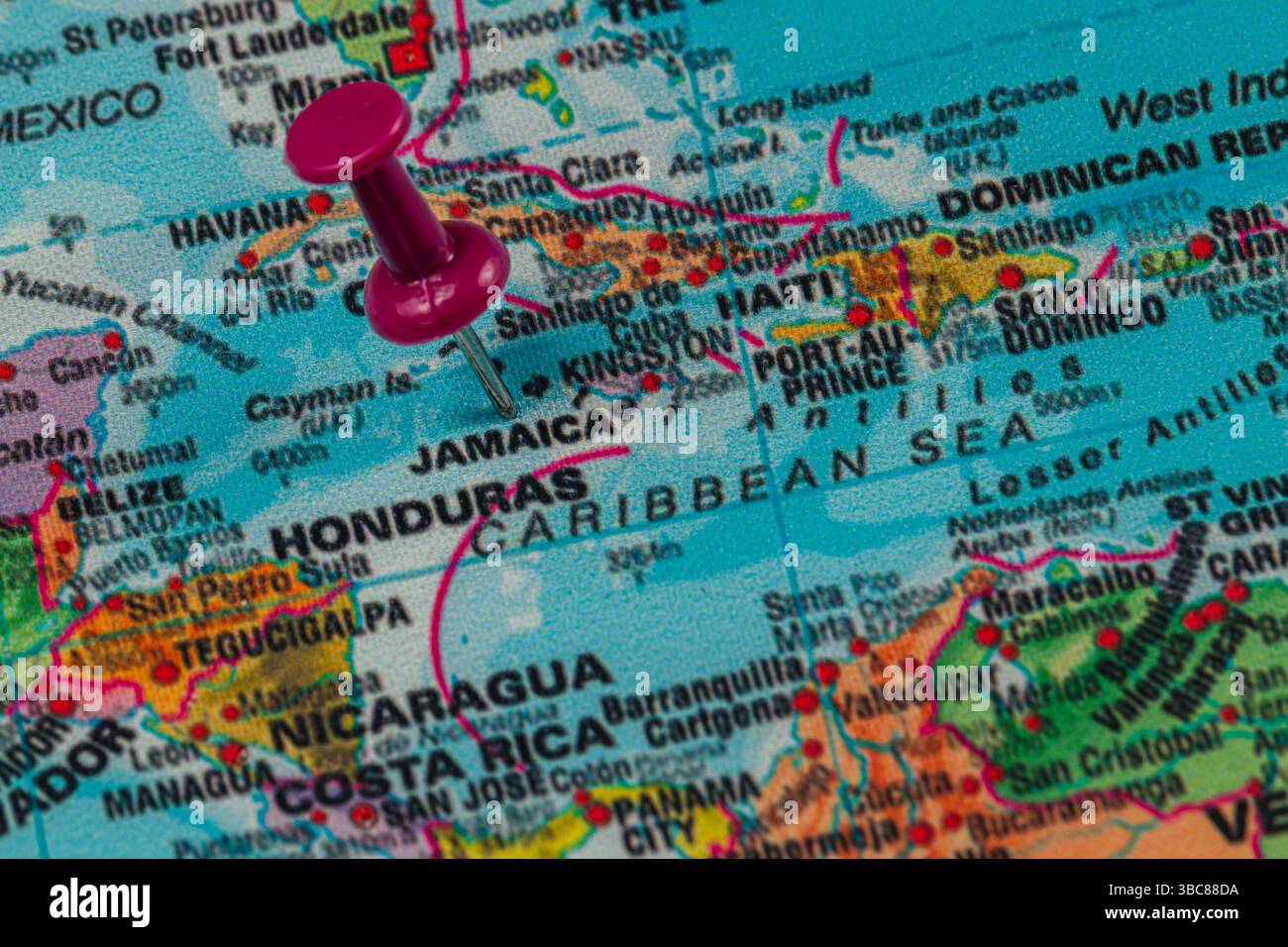 Una vista ravvicinata di una mappa che mostra la Giamaica con una spilla rosa che segna la sua posizione nel Mar dei Caraibi, evidenziando i paesi e le acque circostanti. Foto Stock Una vista ravvicinata di una mappa che mostra la Giamaica con una spilla rosa che segna la sua posizione nel Mar dei Caraibi, evidenziando i paesi e le acque circostanti. Foto Stock