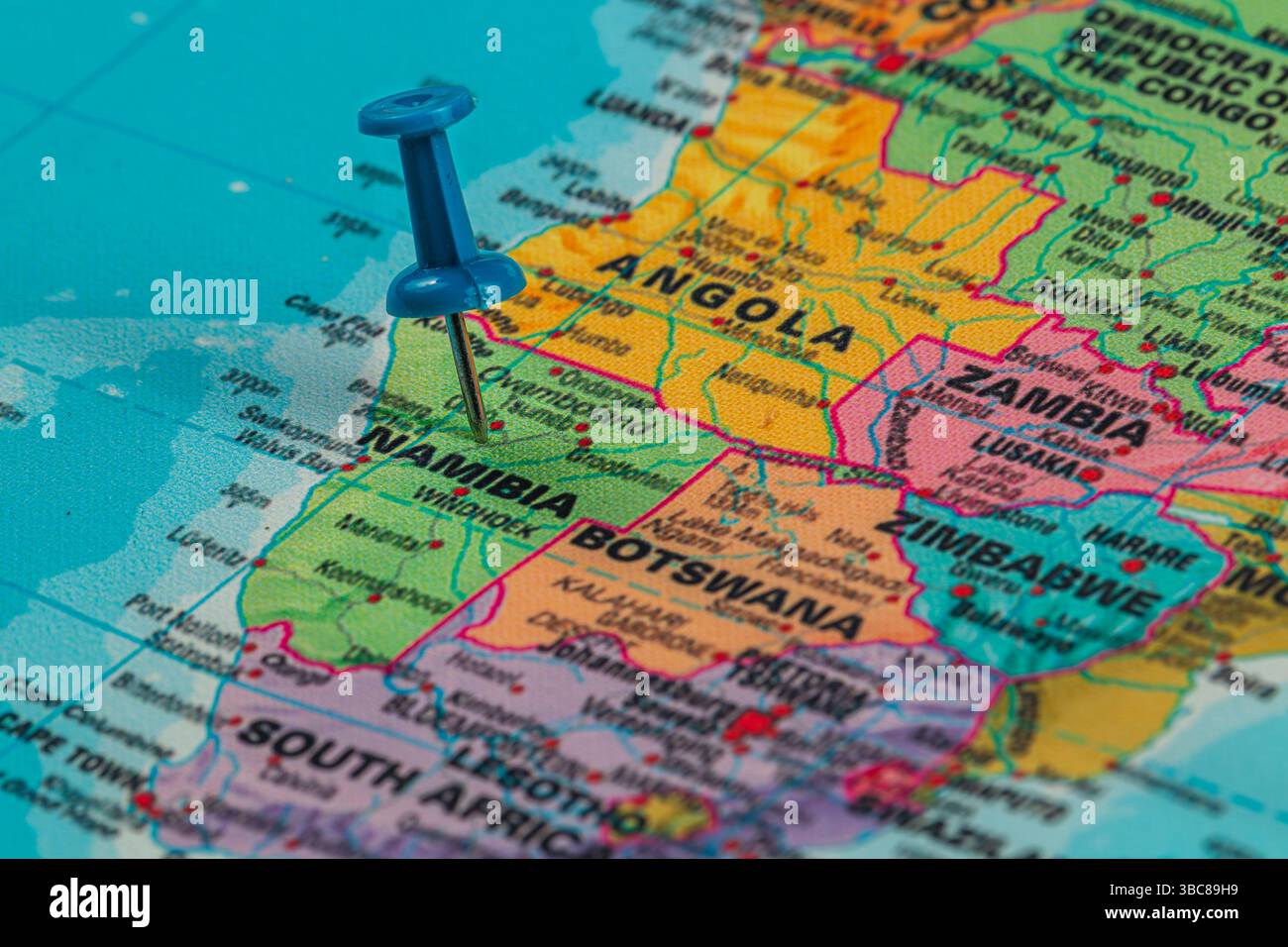 Una puntura blu segna un punto su una mappa dettagliata dell'Africa meridionale, evidenziando la Namibia e i paesi vicini come l'Angola e il Botswana. Foto Stock Una puntura blu segna un punto su una mappa dettagliata dell'Africa meridionale, evidenziando la Namibia e i paesi vicini come l'Angola e il Botswana. Foto Stock