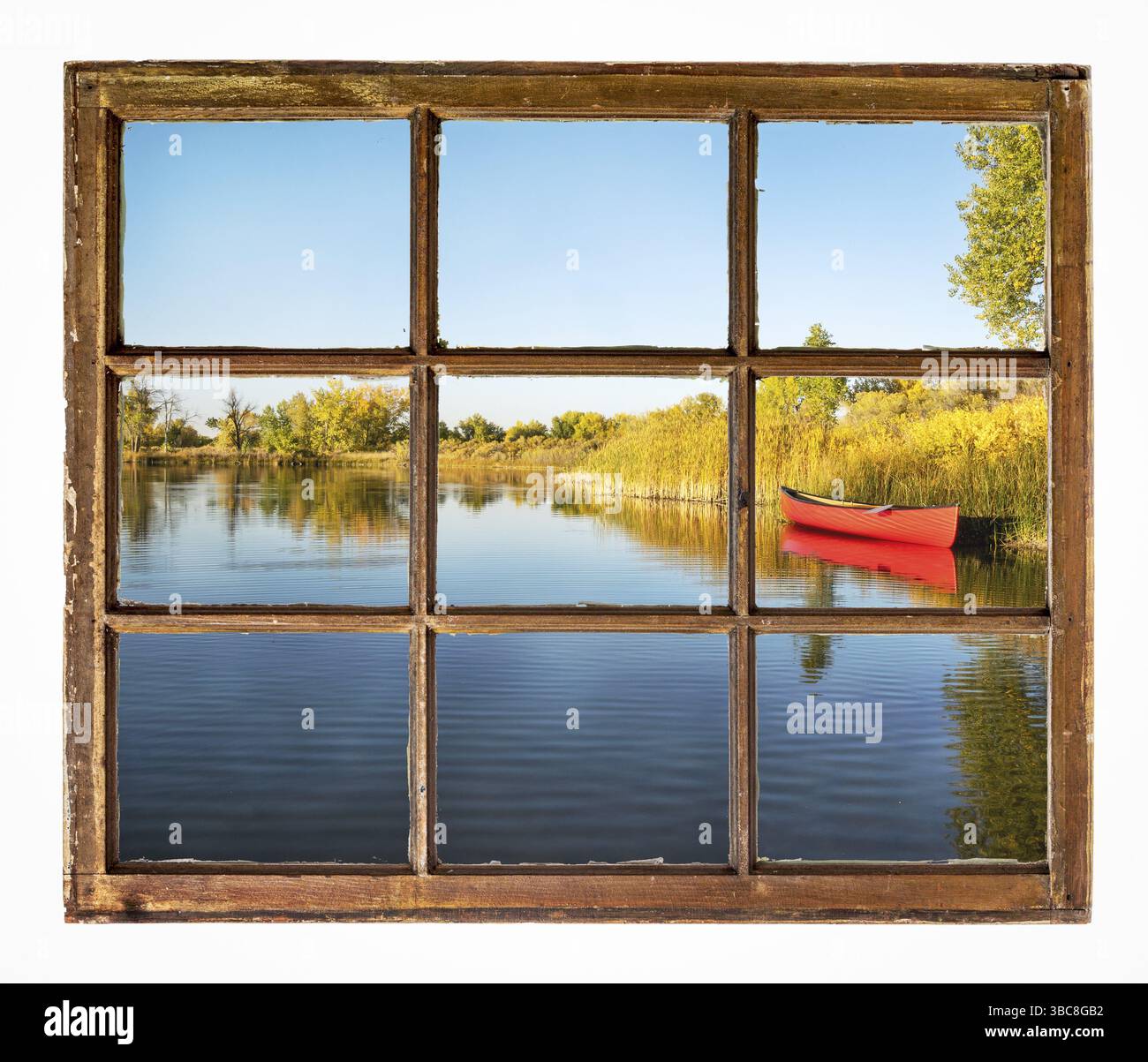 Canoa tandem rossa su una tranquilla riva del lago, vista dalla finestra di una cabina d'epoca e dal paesaggio autunnale Foto Stock