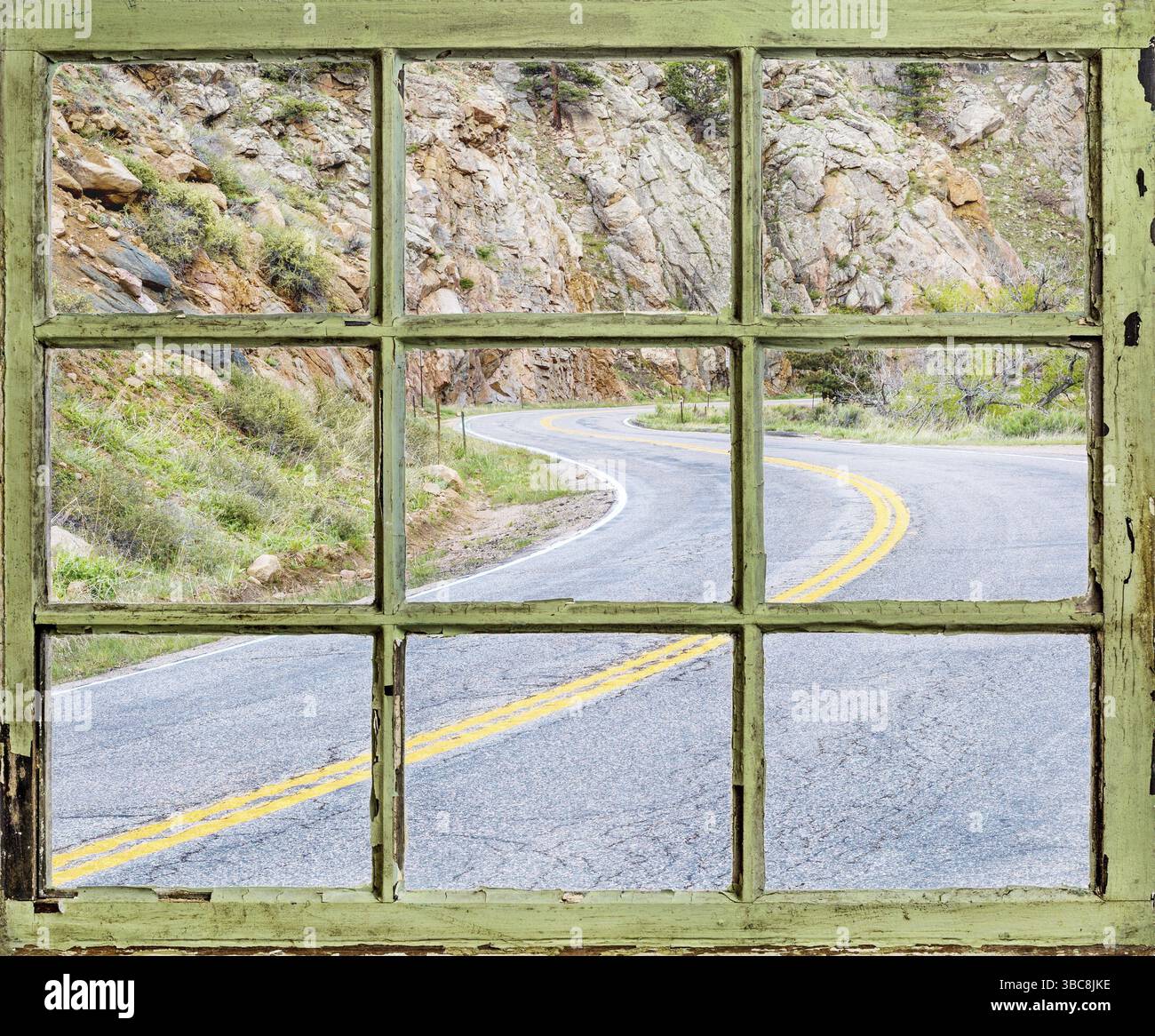 Concetto di viaggio - una vista della strada ventosa di montagna attraverso vintage, grunge, finestra con vetri sporchi Foto Stock