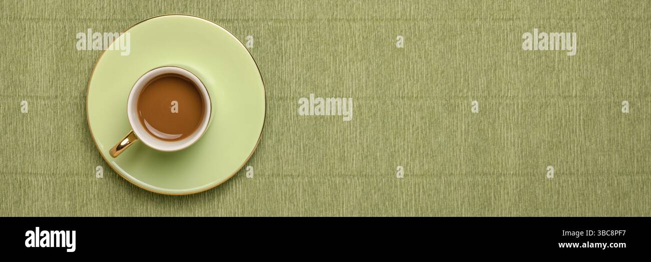 Tazza di caffè verde su sfondo verde crespato italiano con uno spazio di copia, formato banner lungo Foto Stock