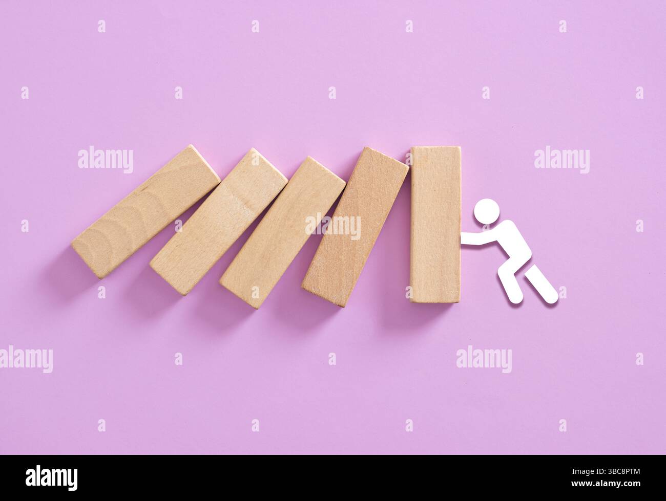 Uomo d'affari che blocca l'effetto domino, il concetto di business, la strategia, la gestione delle crisi, le soluzioni e la risoluzione dei problemi Foto Stock