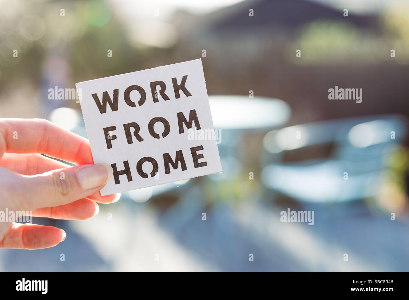 lavoro da casa segno di essere tenuta di fronte al sole fuori del backard fuoco con tavolo e sedie, concetto di nomadi digitali che lavorano a distanza o wfh giorni du Foto Stock