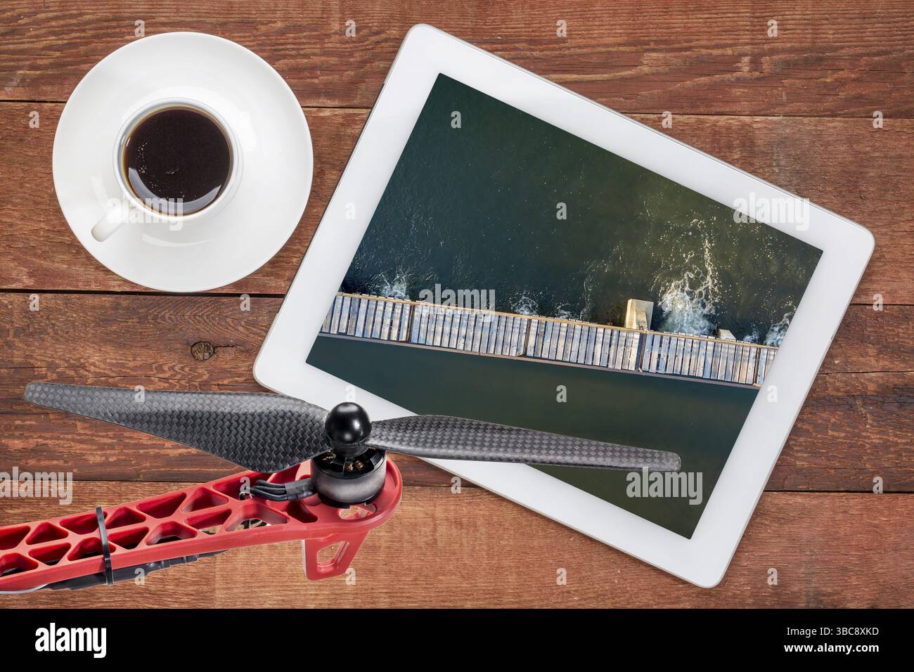 Concetto di fotografia di paesaggio aereo - rivedere le immagini aeree di una diga di diversione del fiume su un tablet digitale con un'elica di droni in primo piano, sc Foto Stock