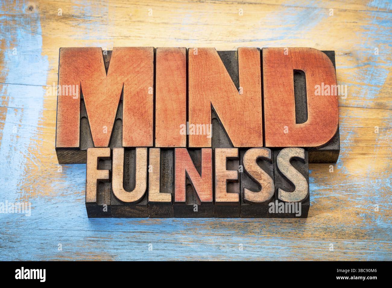 Parola di mindfulness astratta o banner - concetto di consapevolezza - testo in legno letterpress d'epoca macchiato da inchiostri colorati su sfondo in legno grunge Foto Stock