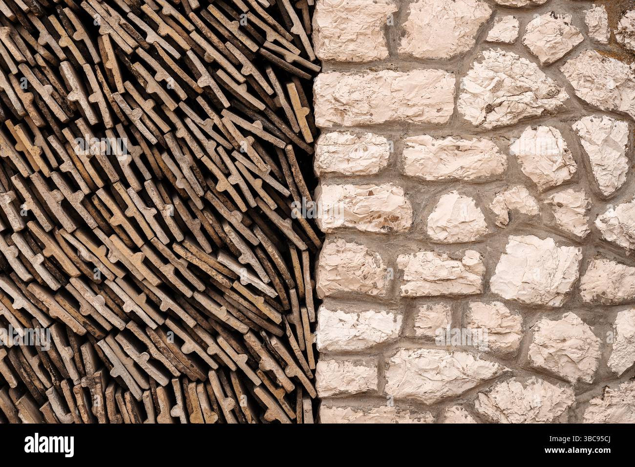 Schema di vecchie tegole usurate impilate accanto a un muro di pietra Foto Stock