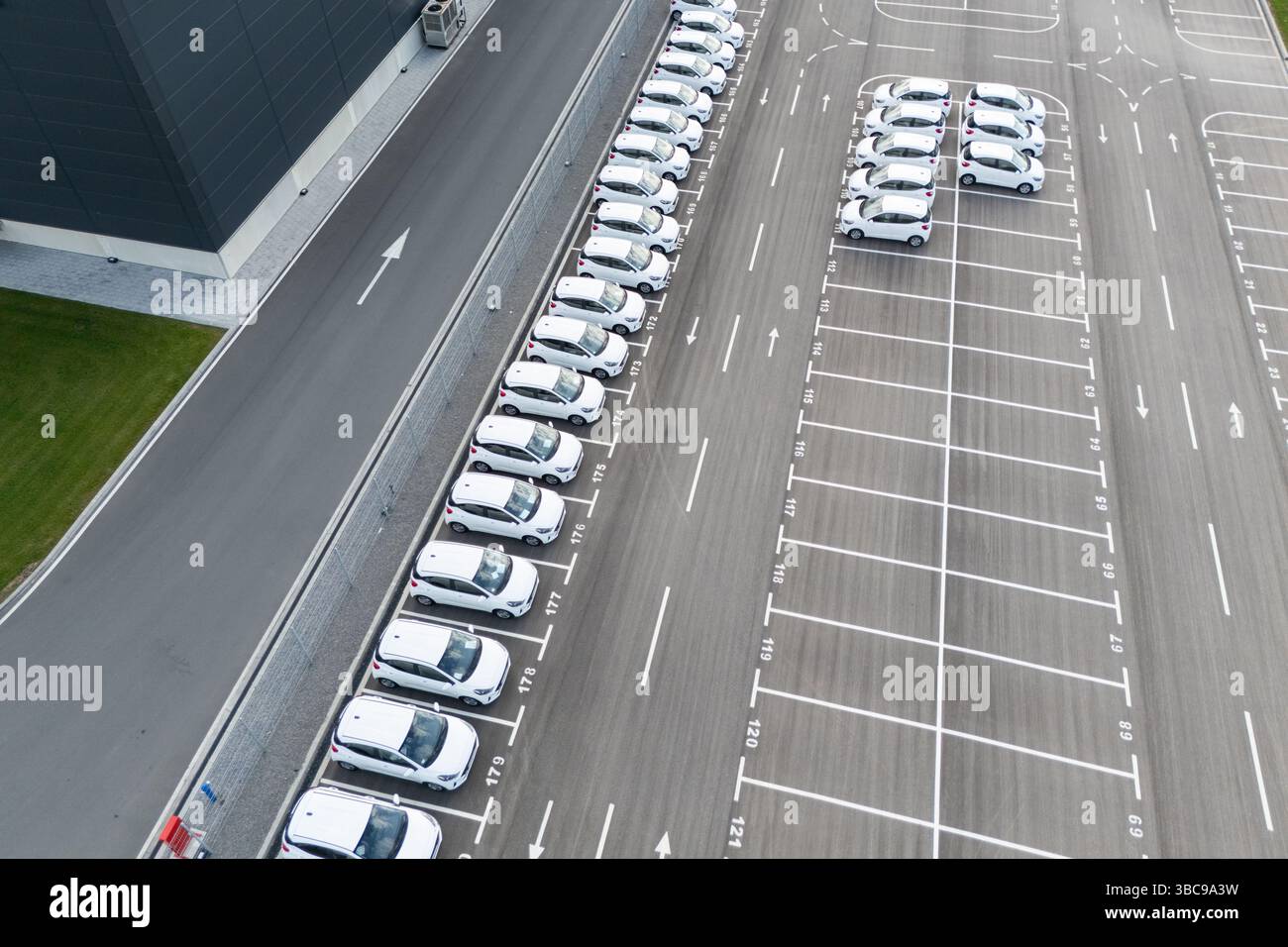 Flotta di veicoli per il merchandising parcheggiata accanto a un centro logistico. Vista aerea. Foto Stock