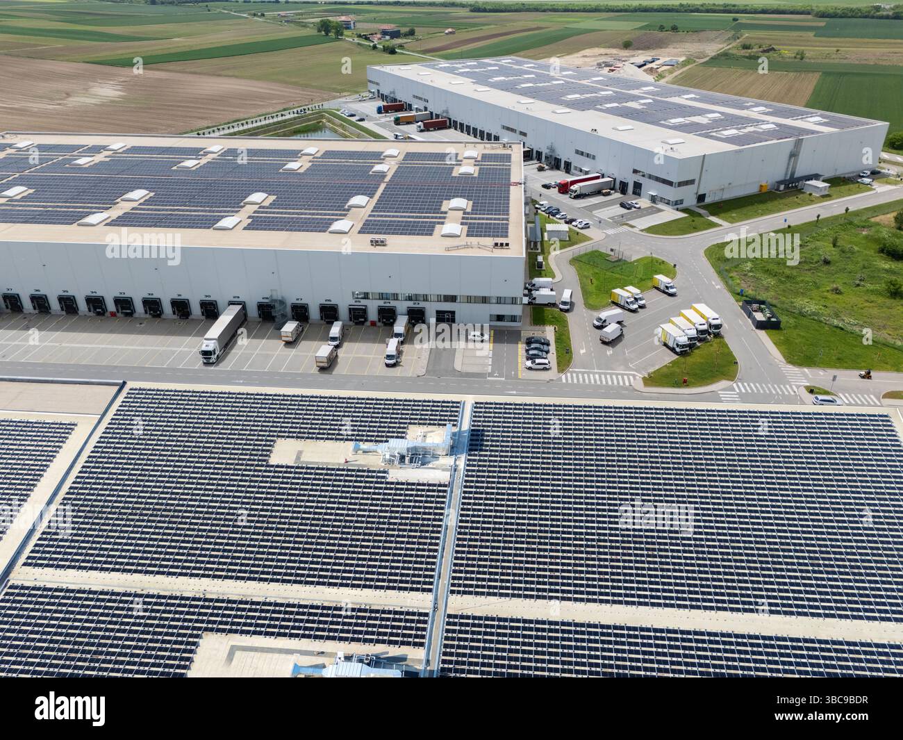 Centri logistici con pannelli solari sui tetti. Vista aerea. Foto Stock