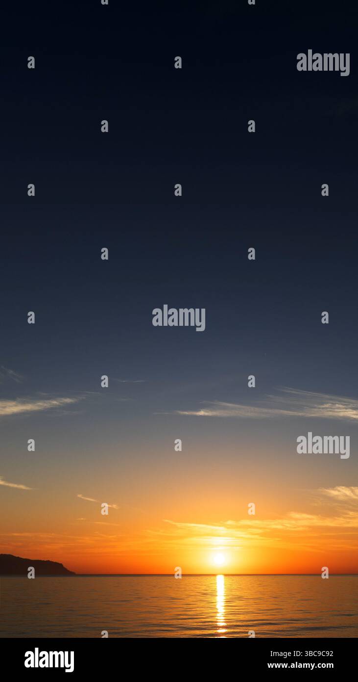 Alba sul mare con onde dolci e stelle che svaniscono in un'atmosfera tranquilla e da sogno Foto Stock
