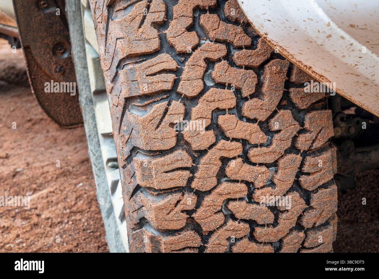 Primo piano del battistrada di pneumatici fuoristrada di un'auto SUV 4x4 o di un veicolo su una strada sterrata, fuoristrada, attività ricreative e di viaggio Foto Stock