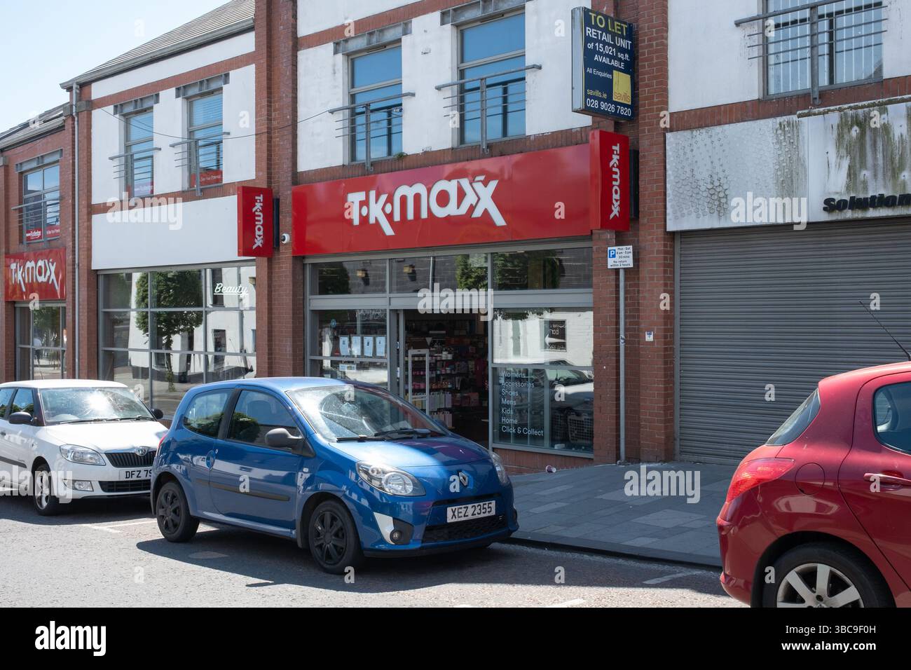 Ballymena, Irlanda del Nord - 18 maggio 2025: Logo rosso bianco dello shopfront marchiato TK Maxx, negozio di abbigliamento per la casa, negozi di moda, negozi di alta moda, business britannico Foto Stock