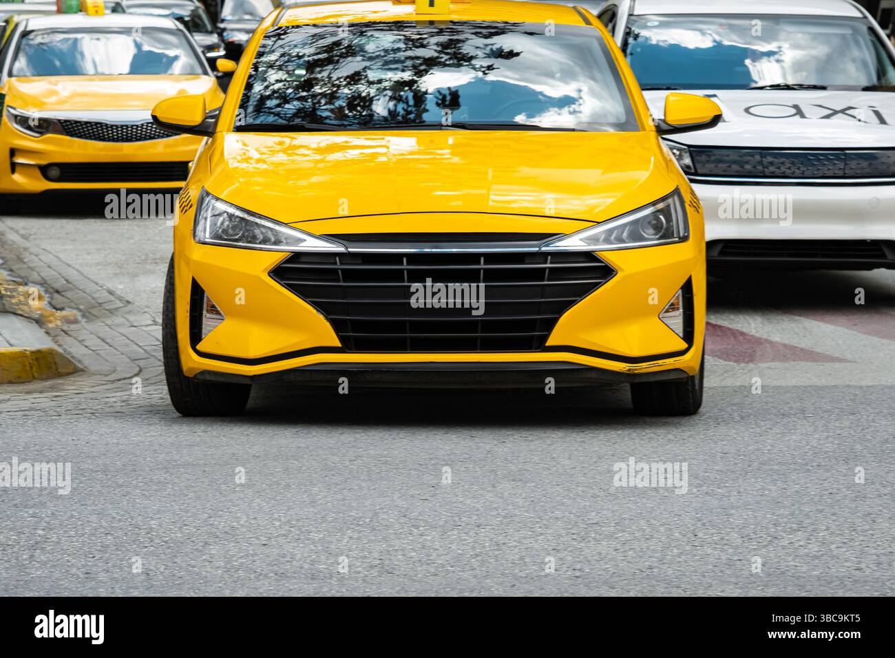 Moderni taxi gialli sulla strada della città. Ci sono molti taxi che guidano in centro. Foto di viaggio, nessuno, vista strada, messa a fuoco selettiva Foto Stock