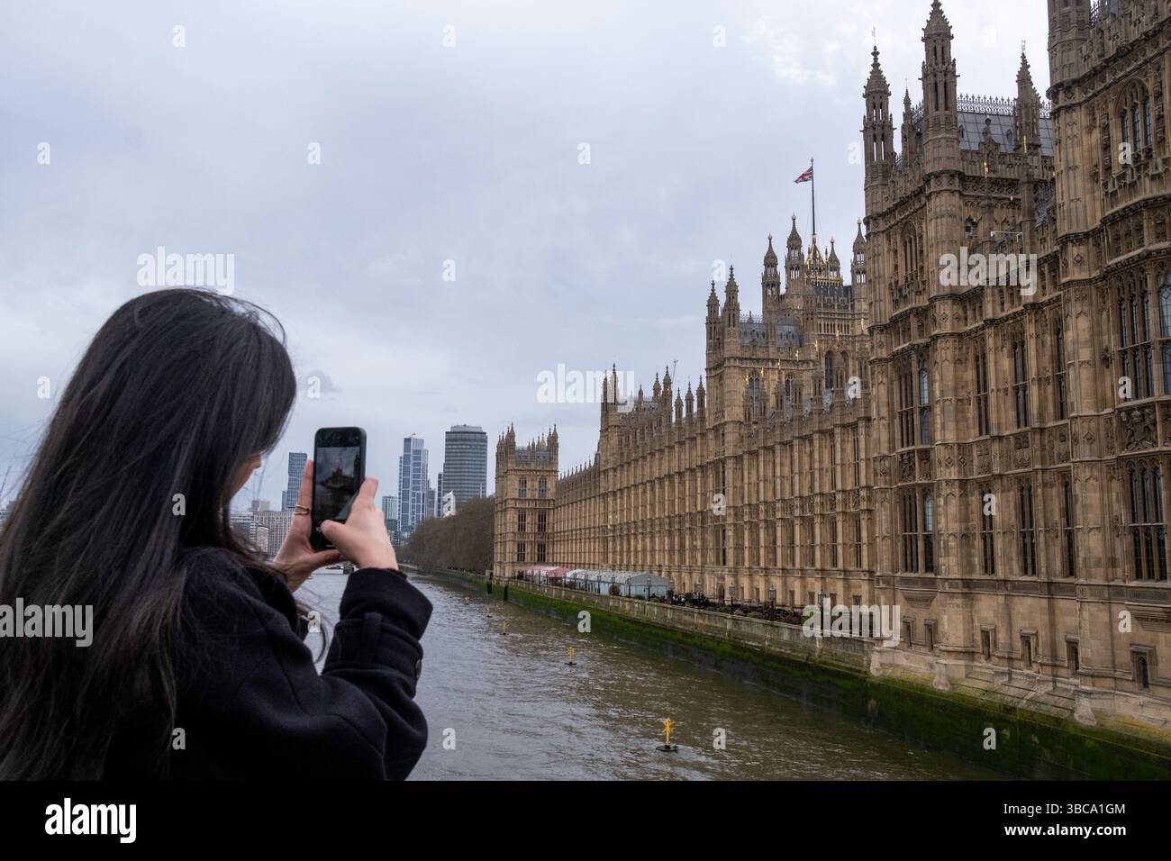 Turista che scatta una foto con il suo smartphone alla periferia del Palazzo di Westminster con il Big Ben nella città di Londra capitale dell'Inghilterra e l'uni Foto Stock