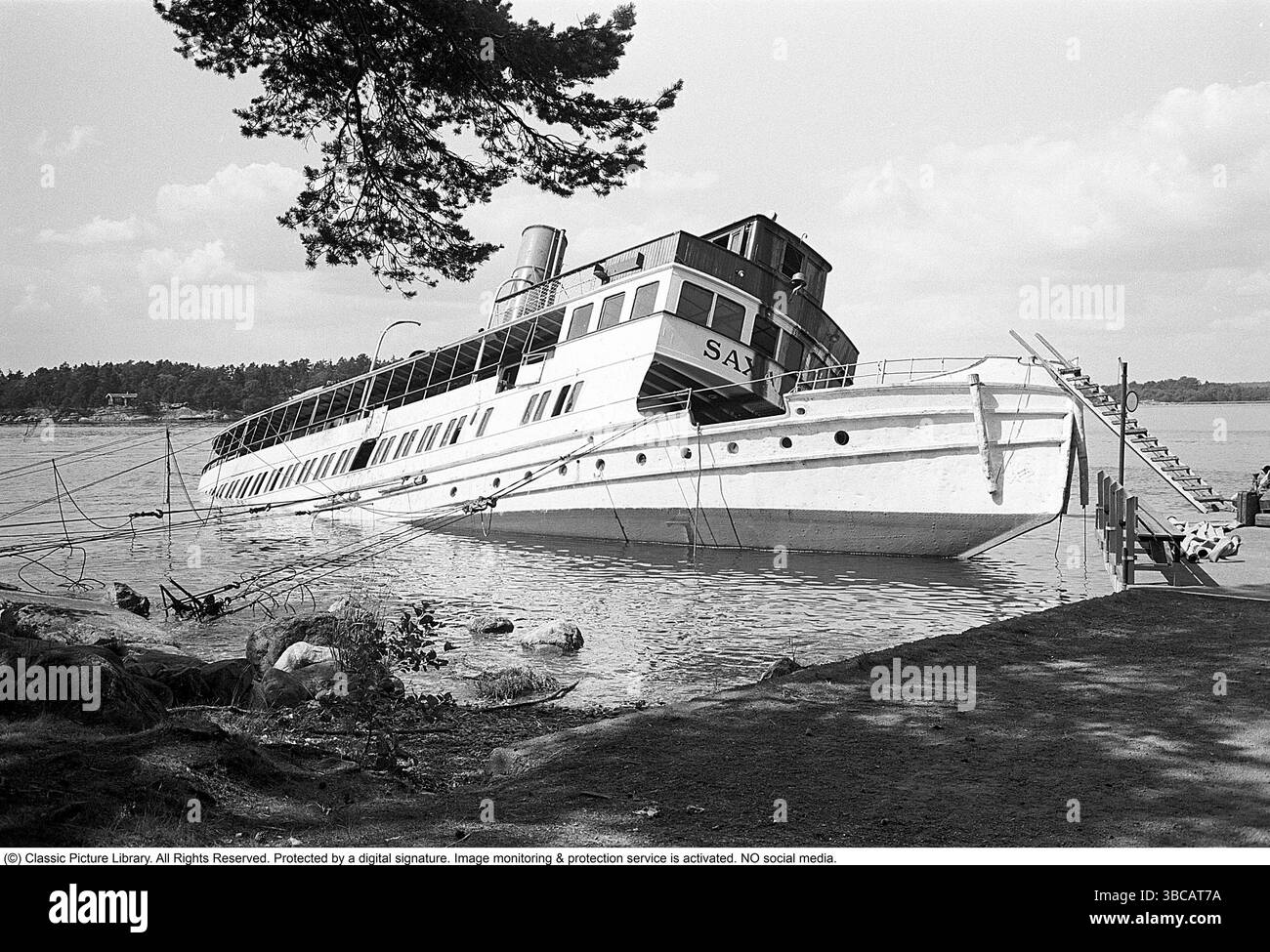 Il Saxaren capitalizza e affonda al molo di Stor-Kråns nella parte occidentale di Saxarfjärden nel maggio 1964. La nave è considerata un relitto e, nel 1973, è acquisita dalla compagnia di navigazione Strömma, dove è riportata al suo nome originale, S/S Gustafsberg VII. Foto Stock