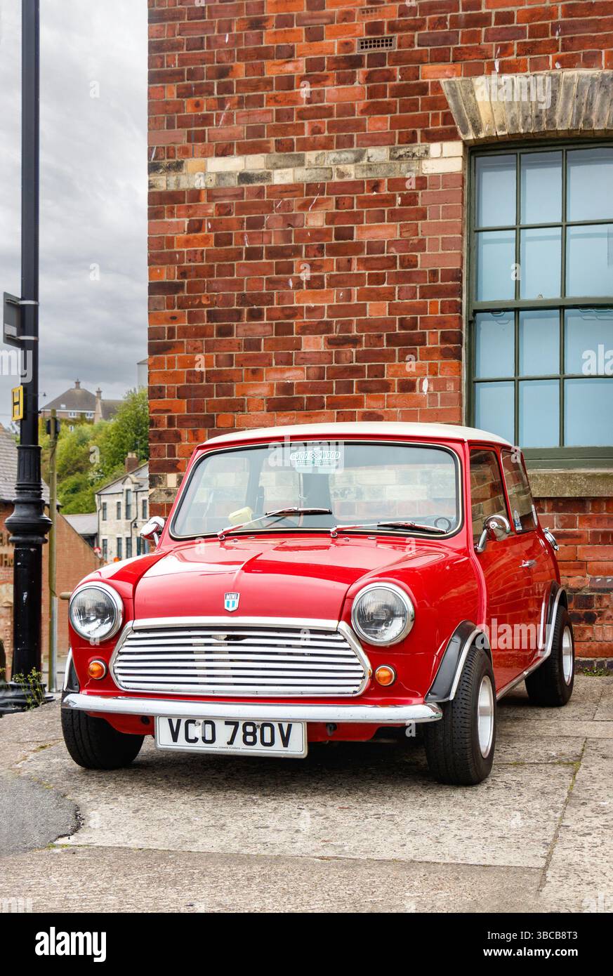 Una mini Cooper classica rossa vibrante con tetto bianco, edifici sullo sfondo negli scudi nord Foto Stock