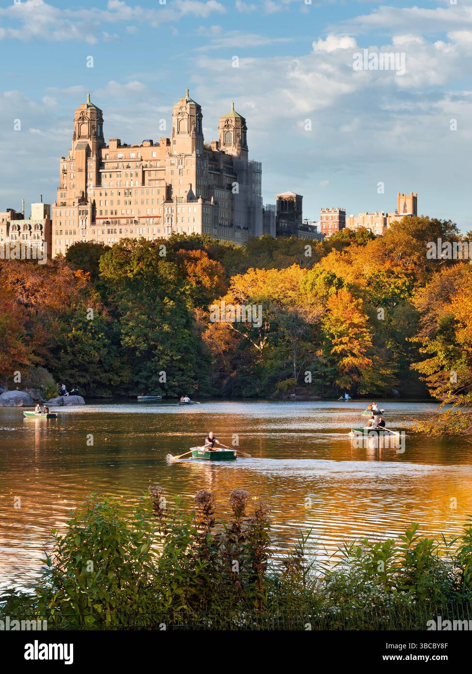 Central Park Lake in autunno con barche a remi e vista del caratteristico edificio Beresford nell'Upper West Side di Manhattan. New York Foto Stock
