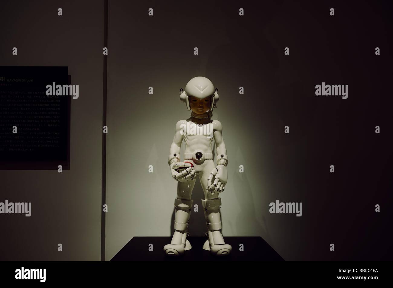 Il futuristico allenatore di Pokémon con armatura in porcellana tiene una Poké Ball con intensità tranquilla alla mostra Pokémon x Kogei Foto Stock