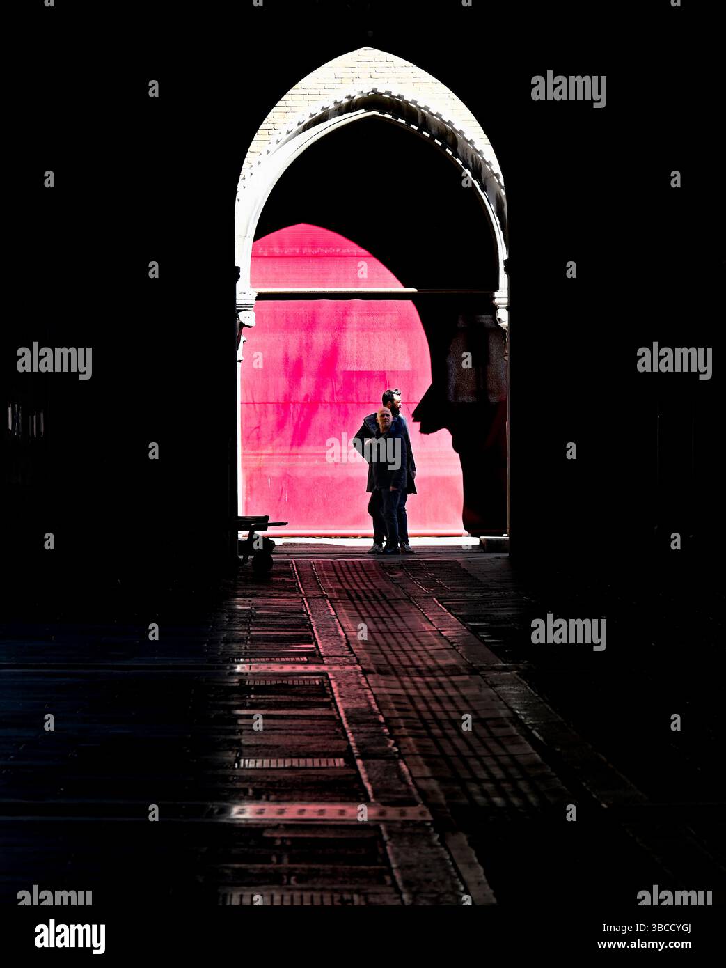 Appoggiato contro una porta rossa Foto Stock