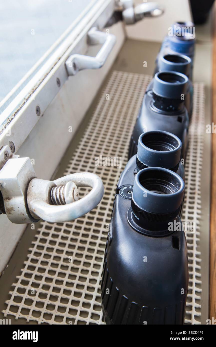 Diversi binocoli su un ponte navale vicino all'oblò. Foto Stock