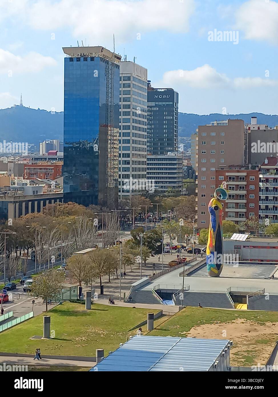 Barcellona, Catalogna, Spagna. 9 aprile 2025. Vista della vibrante scultura di Joan Miró Dona i Ocell in uno spazio pubblico verde circondato da edifici della città e. Foto Stock