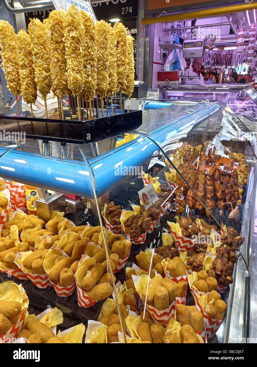 Barcellona, Catalogna, Spagna. 10 aprile 2025. Scene dal mercato la Boqueria con vivaci esposizioni di prosciutto salato tapas, spuntini fritti, involtini di carne e loc Foto Stock