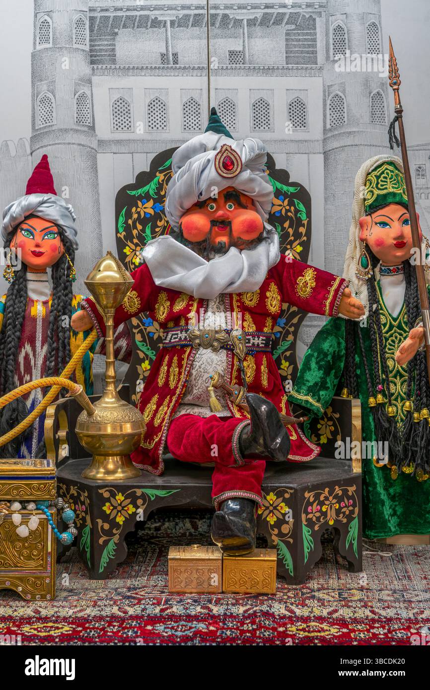 I tradizionali burattini popolari uzbeki a Bukhara, Uzbekistan, sono esposti in vivaci costumi, che esprimono le tradizioni teatrali e artigianali della regione. Foto Stock