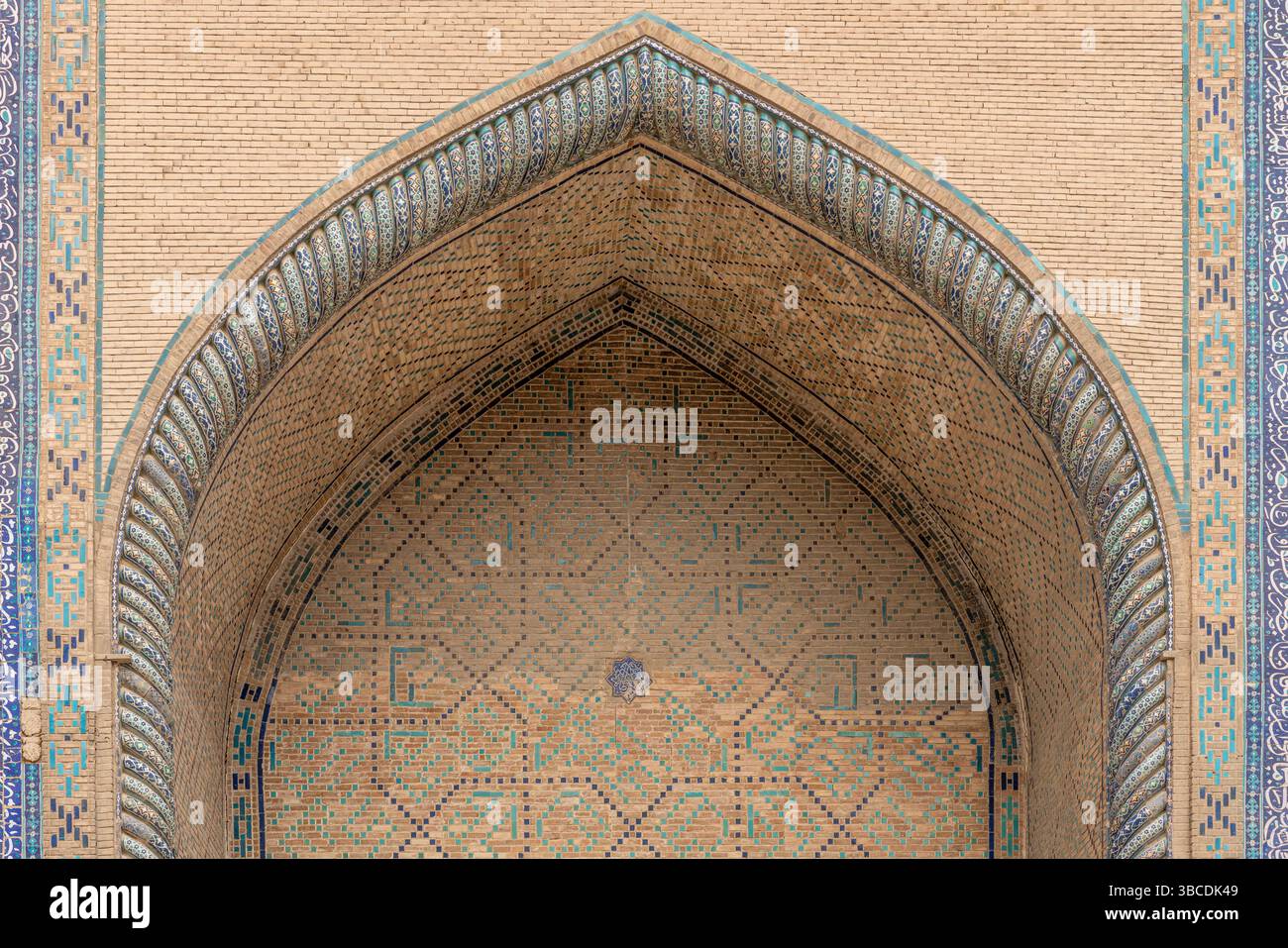 Un arco appuntito con piastrelle sbiadite segna la facciata della Madrasa Ulugbek a Bukhara, Uzbekistan, un'eredità architettonica Timuride duratura. Foto Stock