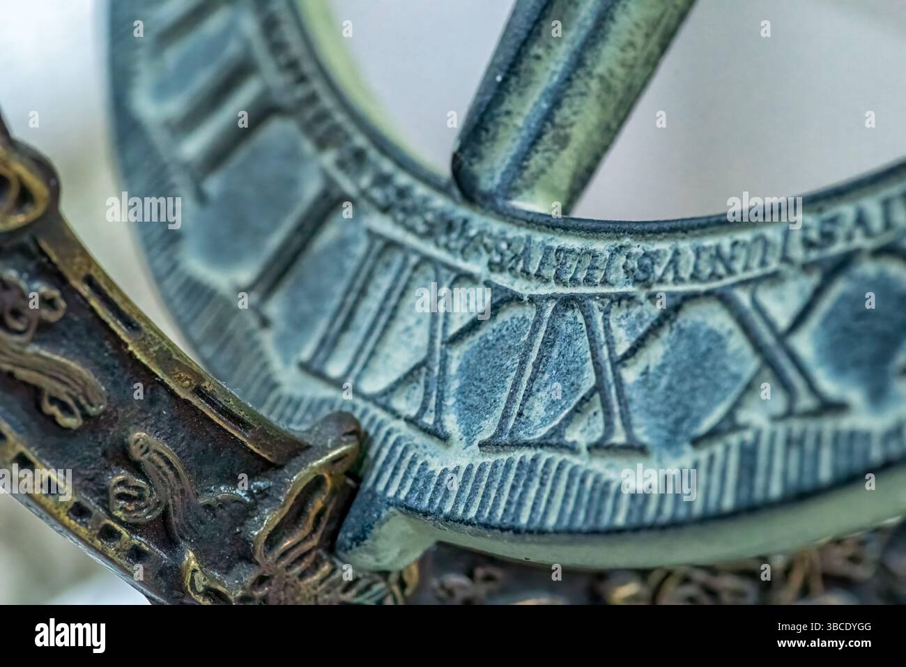 Primo piano di una meridiana decorativa o di una sfera armillare con numeri romani e dettagli decorati, che mettono in risalto l'artigianato e l'antichità. Foto Stock