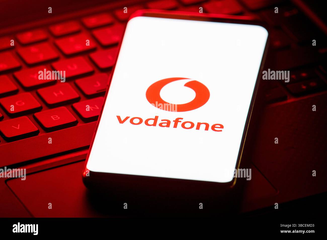 Sullo schermo di uno smartphone viene visualizzata la foto del logo della rete di telefonia mobile Vodafone. Il gigante della telefonia mobile Vodafone ha rivelato di essere sceso a una perdita annuale dopo aver prenotato 4,5 miliardi di euro (3,8 miliardi di sterline) in svalutazioni sulle sue attività in Germania e Romania. Il gruppo ha registrato perdite operative pari a 411 milioni di euro (£346 milioni) per l'anno fino a marzo 31 contro utili pari a 3,67 miliardi (£3,09 miliardi) dell'anno precedente. Data di pubblicazione: Martedì 20 maggio 2025. Foto Stock