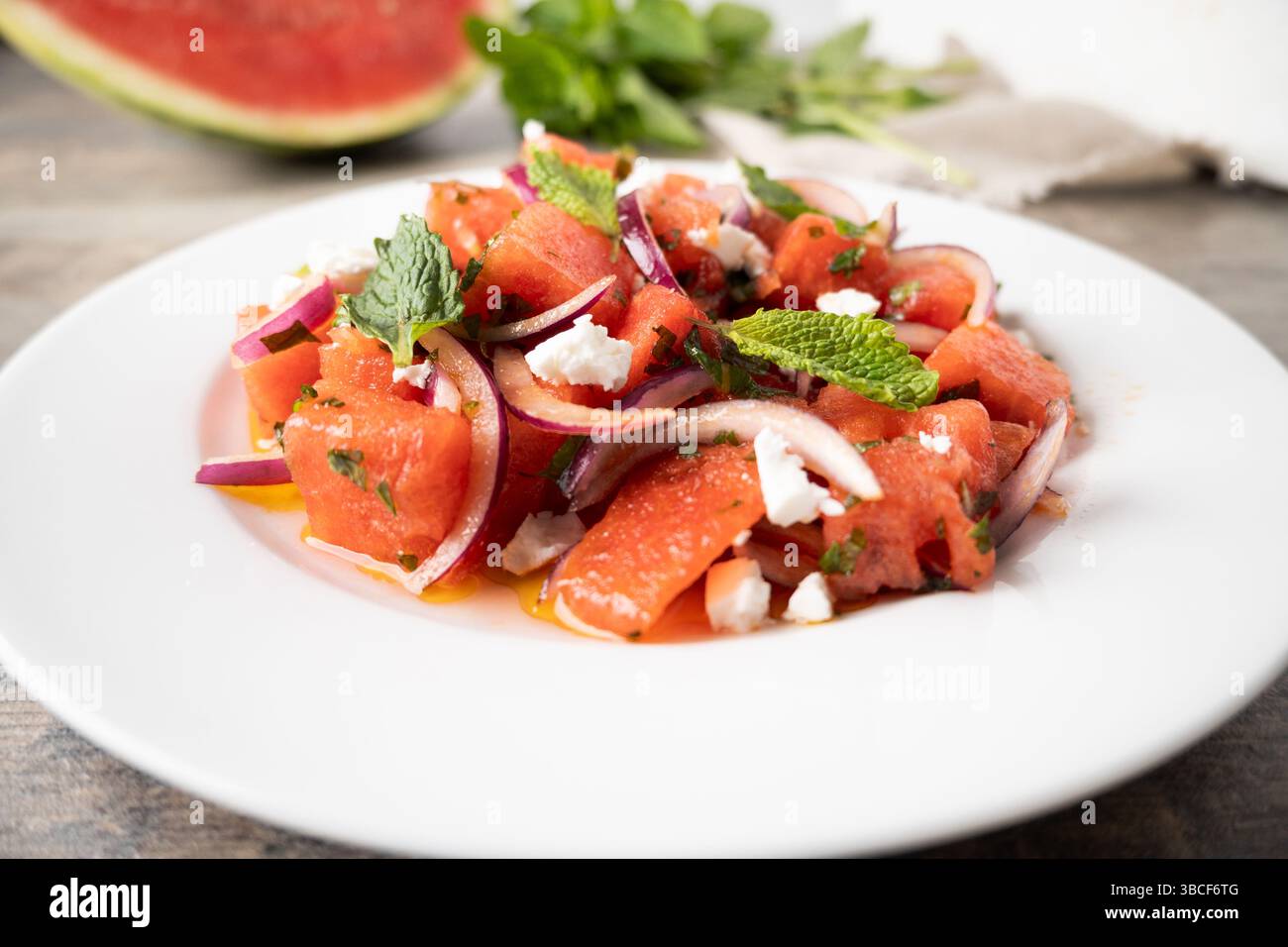 Colorata insalata estiva con succosa anguria, feta sbriciolata, foglie di menta fresca e cipolla rossa a fette sottili. . Foto Stock