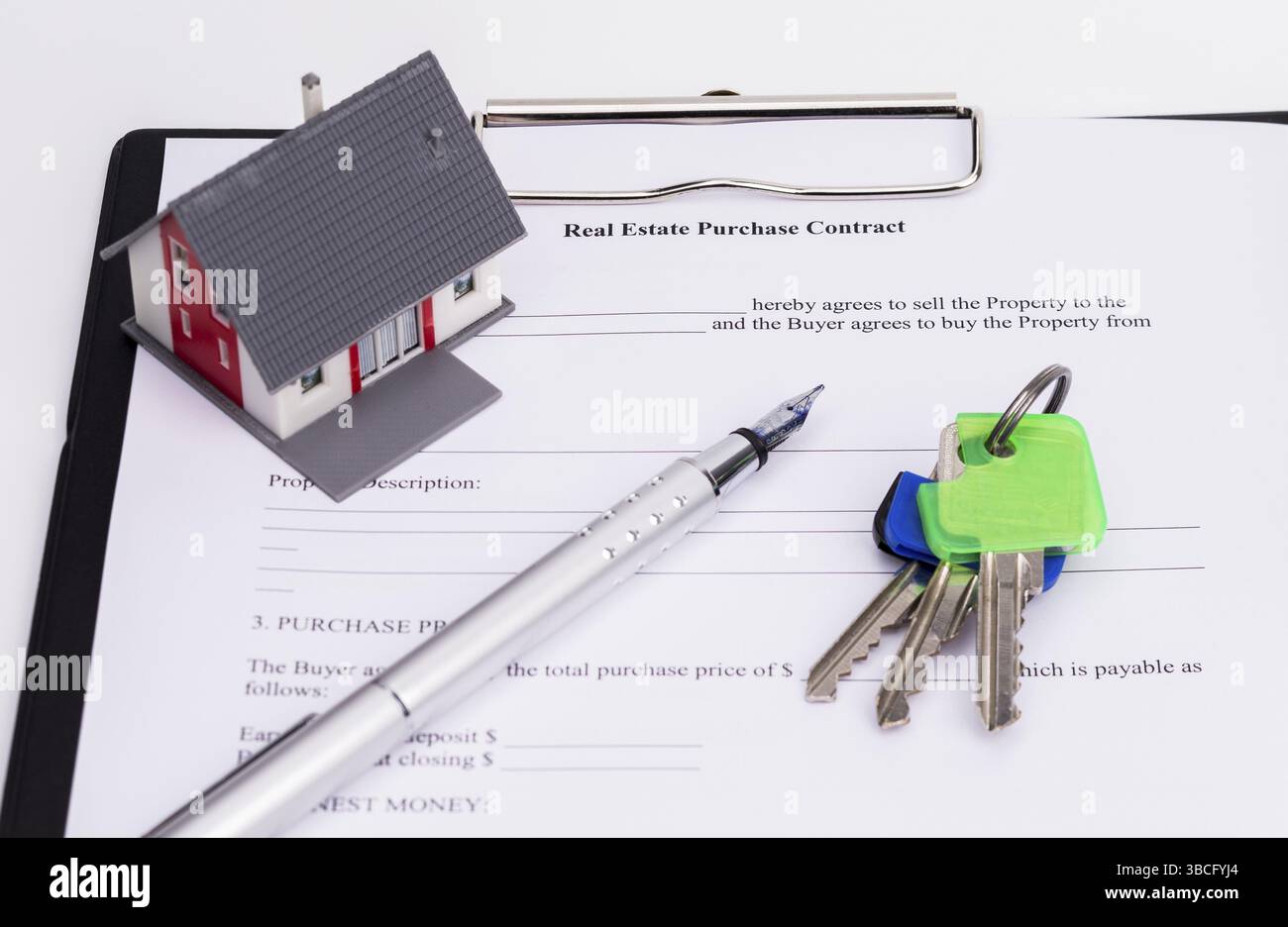 La foto mostra un contratto di vendita con una penna stilografica, una piccola casa e le chiavi della casa Foto Stock