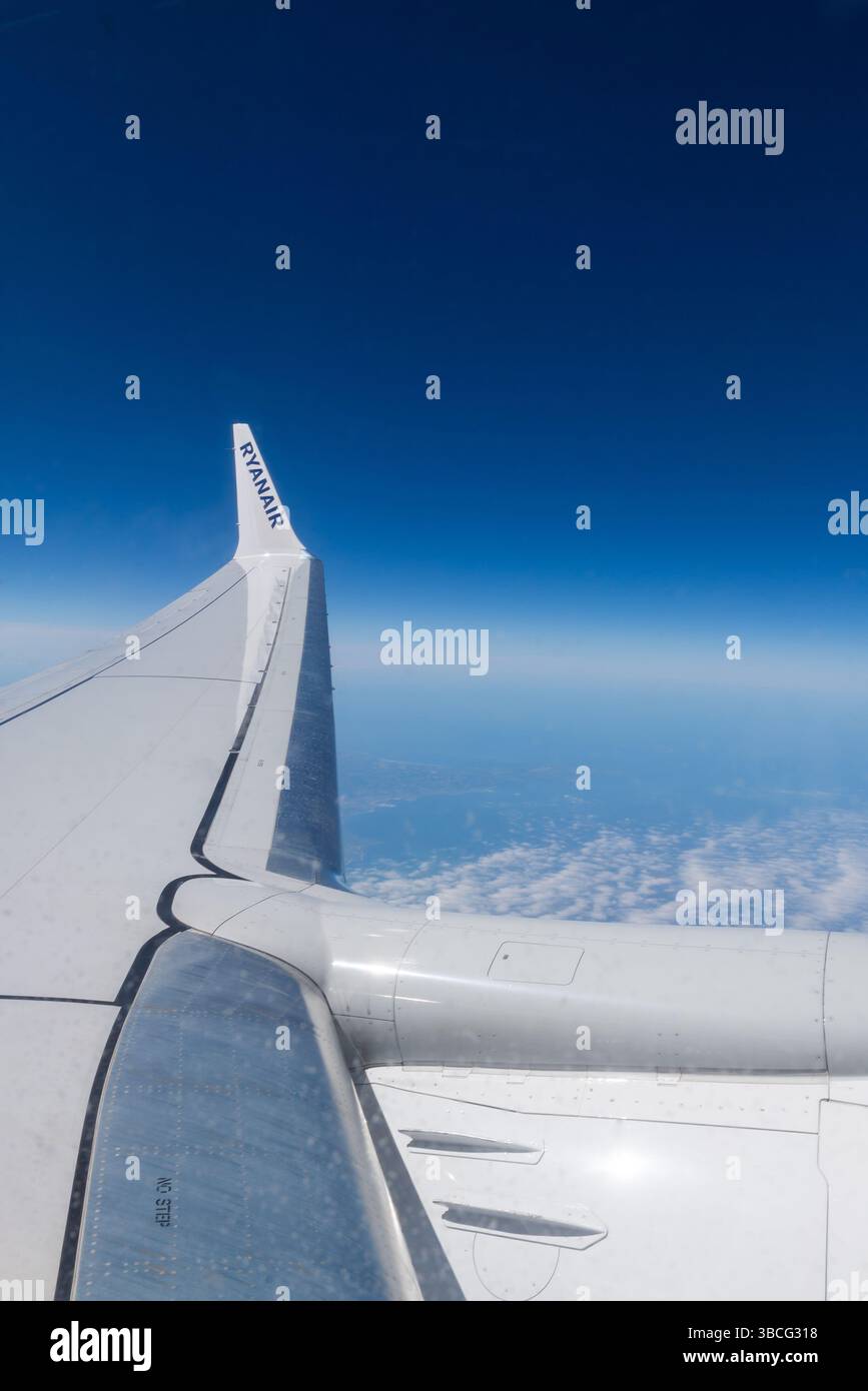 Ala di un Boeing 737 MAX 8200 Ryanair che vola ad alta quota di crociera sopra la Francia, con un cielo blu profondo. Titoli Ryanair su winglet a punta alare Foto Stock