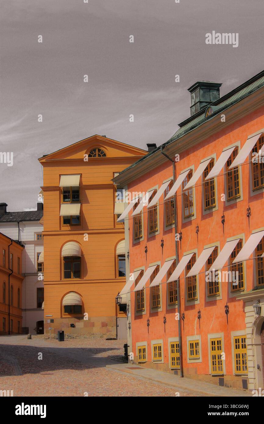 Colorati edifici storici con facciate in ocra e terracotta, persiane in legno e tende classiche nel quartiere della città vecchia di Stoccolma. Foto Stock