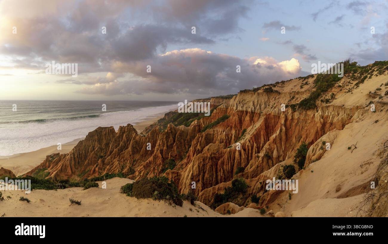 Molte bizzarre dune di sabbia erose sull'Oceano Atlantico con onde che si infrangono al tramonto Foto Stock
