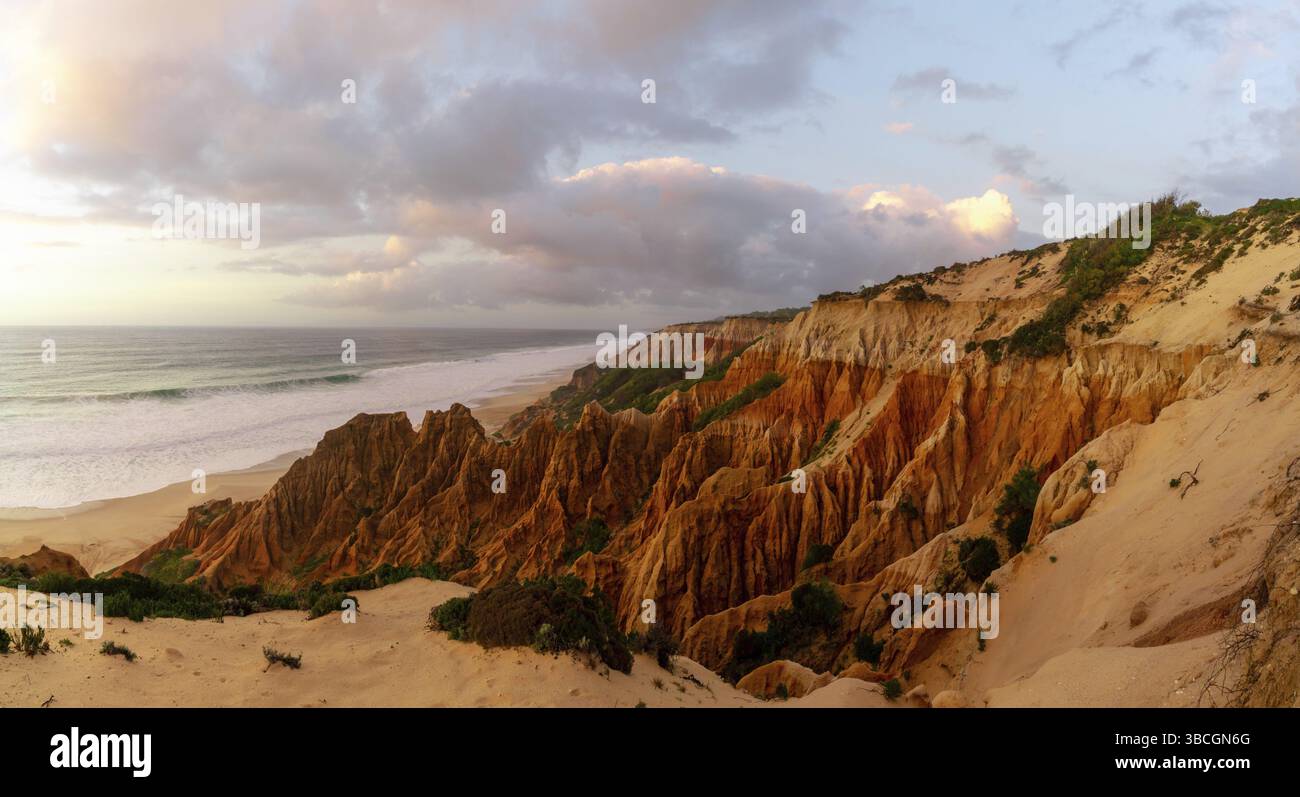 Molte bizzarre dune di sabbia erose sull'Oceano Atlantico con onde che si infrangono al tramonto Foto Stock