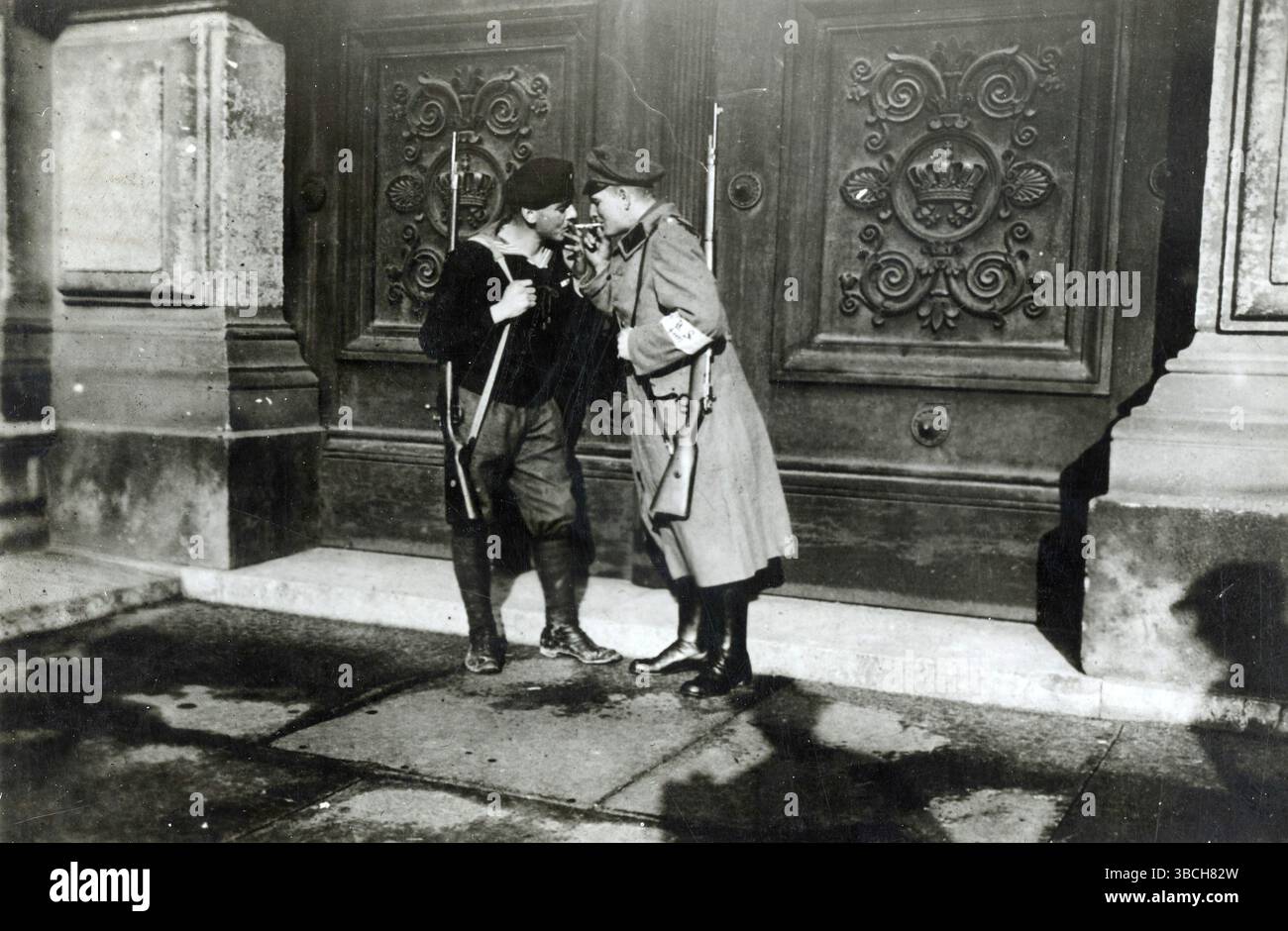 Due membri della Lega Spartaco che sorvegliano la porta del palazzo del deposto re Ludovico II in Baviera. La rivolta spartacista fu una rivolta armata a Berlino dal 5 al 12 gennaio 1919. Fu principalmente una lotta di potere tra i sostenitori del governo provvisorio che favoriva una socialdemocrazia, e quelli del Partito Comunista di Germania (KPD) guidato da Karl Liebknecht e Rosa Luxemburg, che volevano istituire una repubblica sovietica simile ai bolscevichi in Russia. Foto Stock