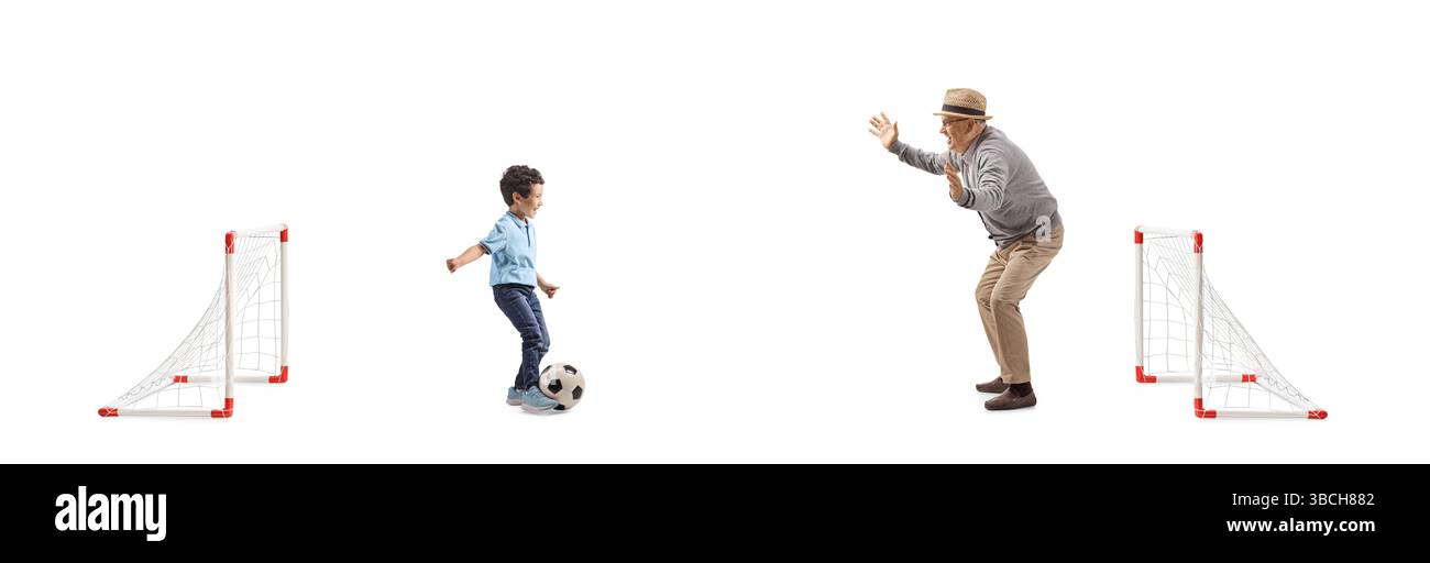 Nonno e ragazzo che giocano a calcio con mini goal isolati su sfondo bianco Foto Stock