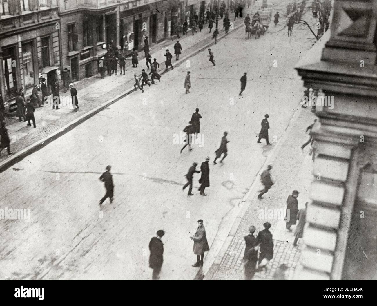 Persone in strada che corrono per la copertura durante la rivolta Spartacista. La rivolta spartacista fu una rivolta armata a Berlino dal 5 al 12 gennaio 1919. Fu principalmente una lotta di potere tra i sostenitori del governo provvisorio che favoriva una socialdemocrazia, e quelli del Partito Comunista di Germania (KPD) guidato da Karl Liebknecht e Rosa Luxemburg, che volevano istituire una repubblica sovietica simile ai bolscevichi in Russia. Foto Stock
