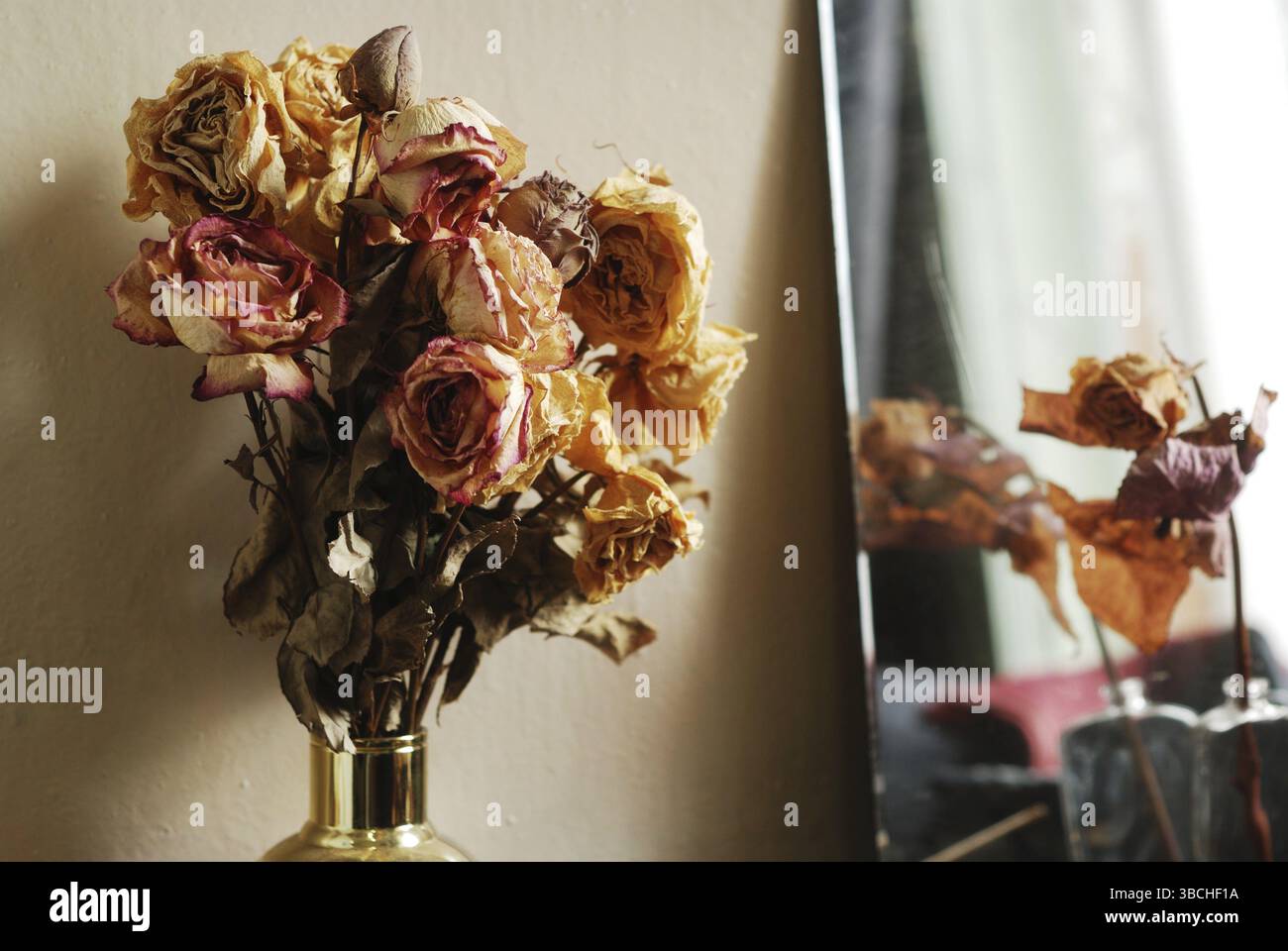 Bouquet di rose secche in vaso dorato Foto Stock