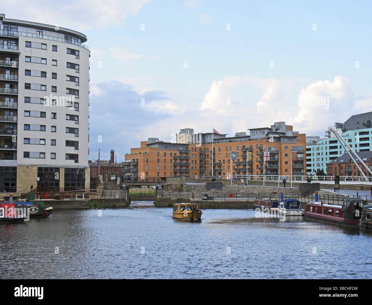 Leeds, West yorkshire, regno unito, 16 luglio 2019: Una vista dei cancelli di blocco al molo di leeds con un taxi d'acqua giallo e le case galleggianti ormeggiate lungo il d Foto Stock