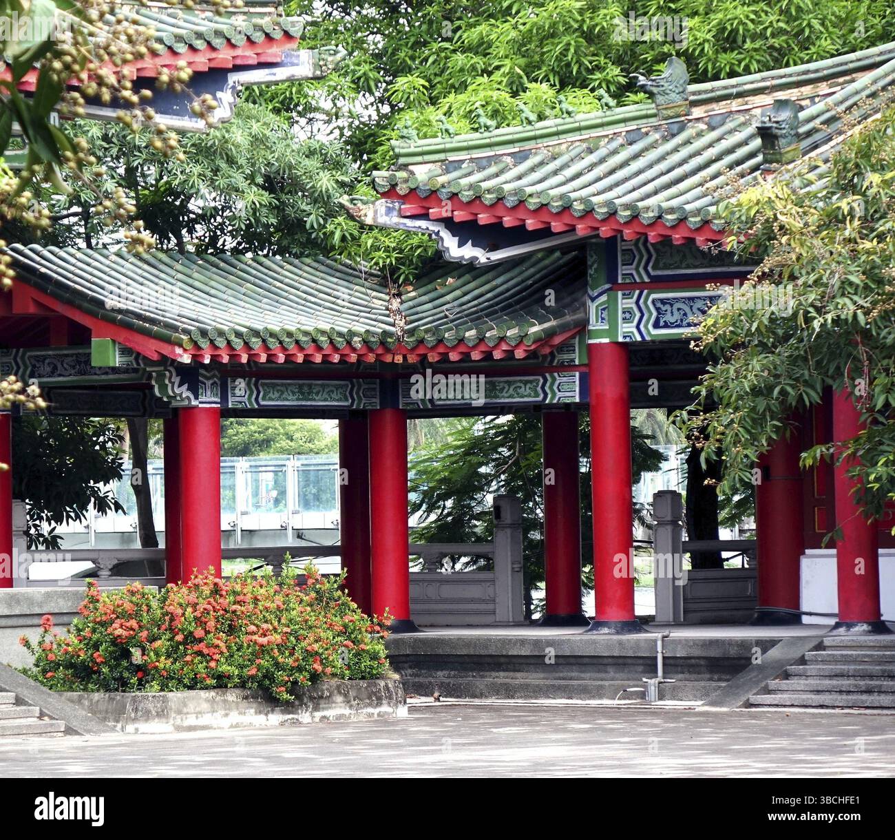 Un tranquillo cortile del tempio con colonne rosse e tegole verdi Foto Stock