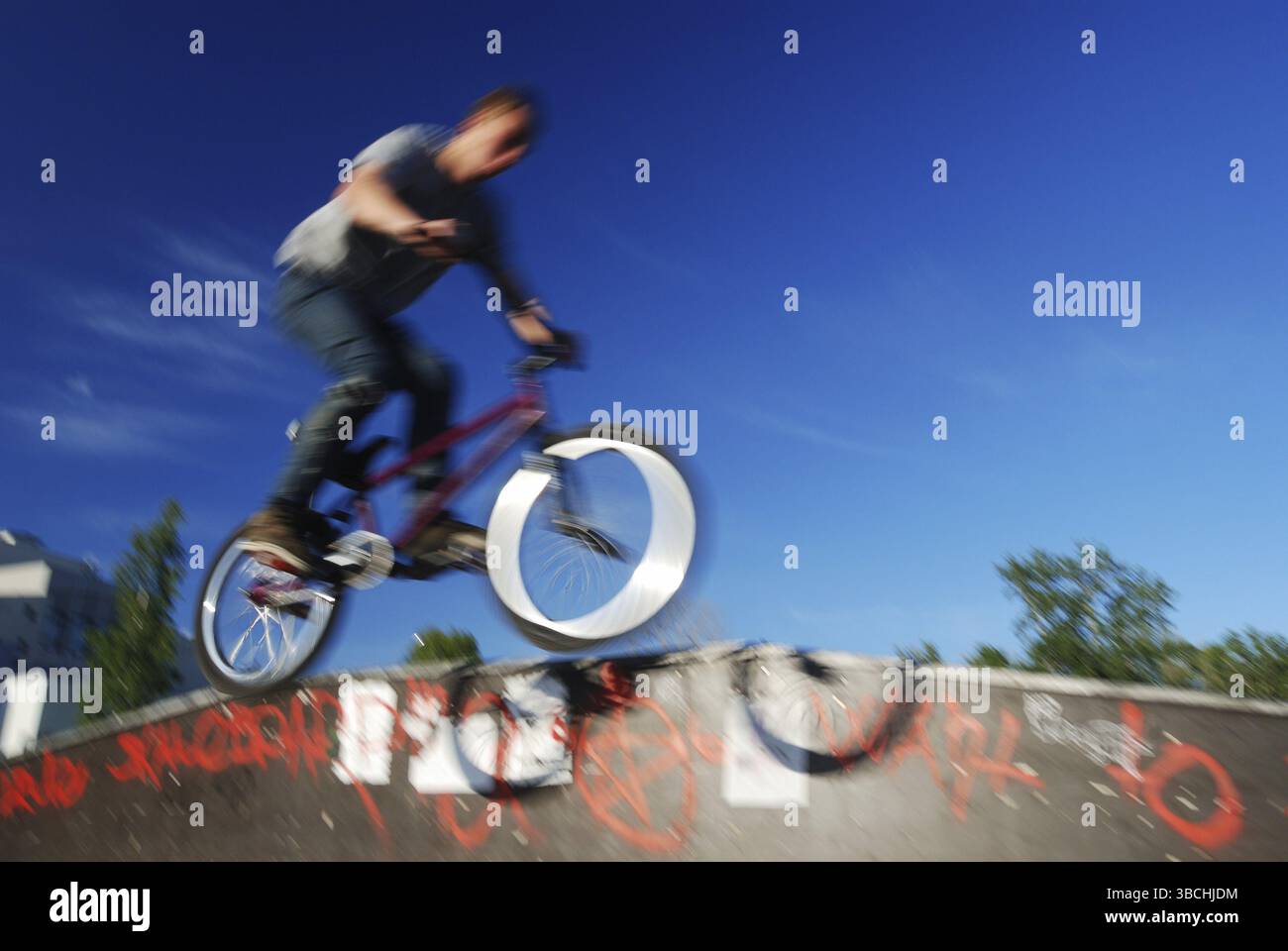 Ciclista che salta contro il cielo blu, foto sfocate Foto Stock