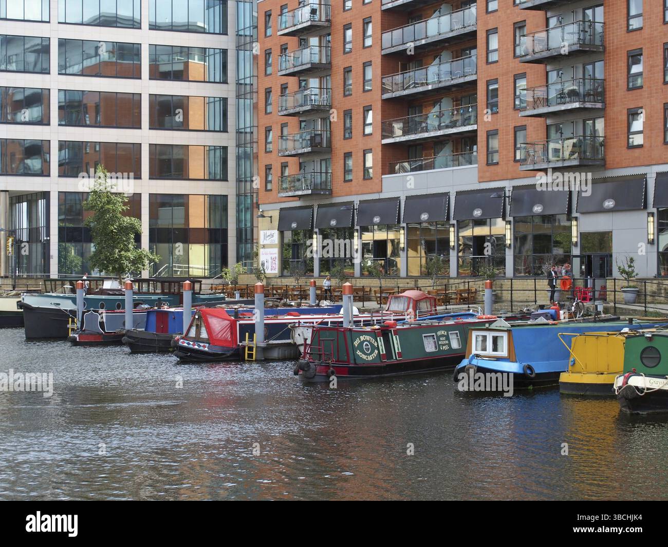 Leeds, West yorkshire, regno unito, 16 luglio 2019: Una vista di leeds molo case galleggianti e chiatte ormeggiate accanto a sviluppi di appartamenti e un restaur Foto Stock