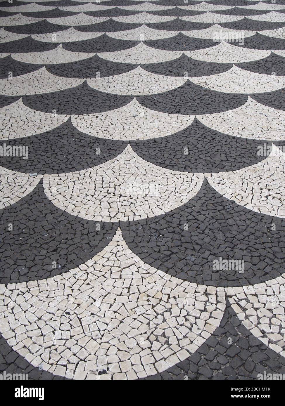 Tradizionale marciapiede di ciottoli con piastrelle in scala di pesce bianco e nero del portogallo a funchal madeira Foto Stock